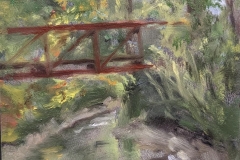 A plein air painting by Cindy Vojnovic of trees and a pedestrian bridge at the Karl Stirner Arts Trail in Easton, Pennsylvania